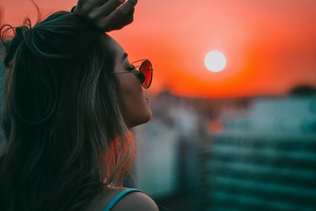 woman in sunglasses looking into the sun