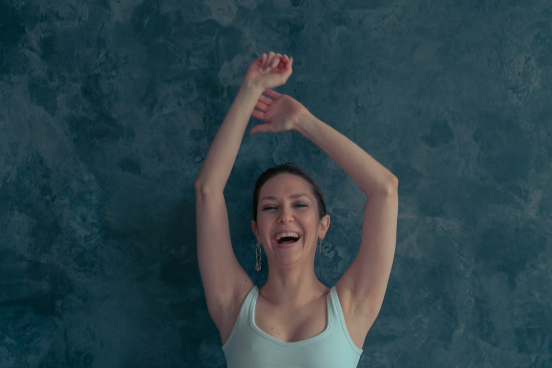 woman raising her arms confidently