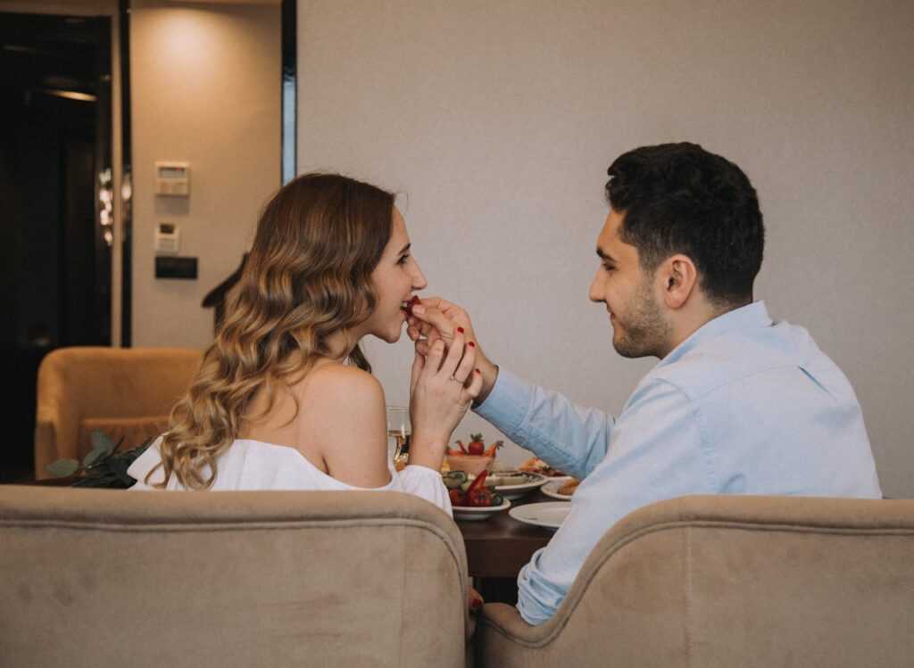 A Couple Sitting at the Table and Eating Together