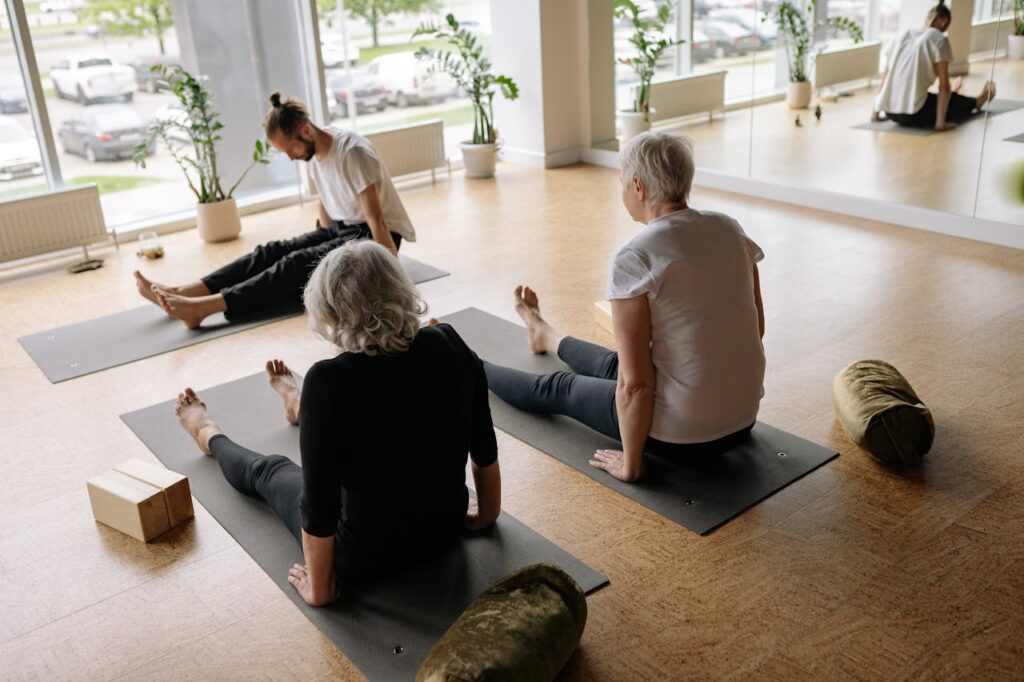 people doing yoga on a wooden floor