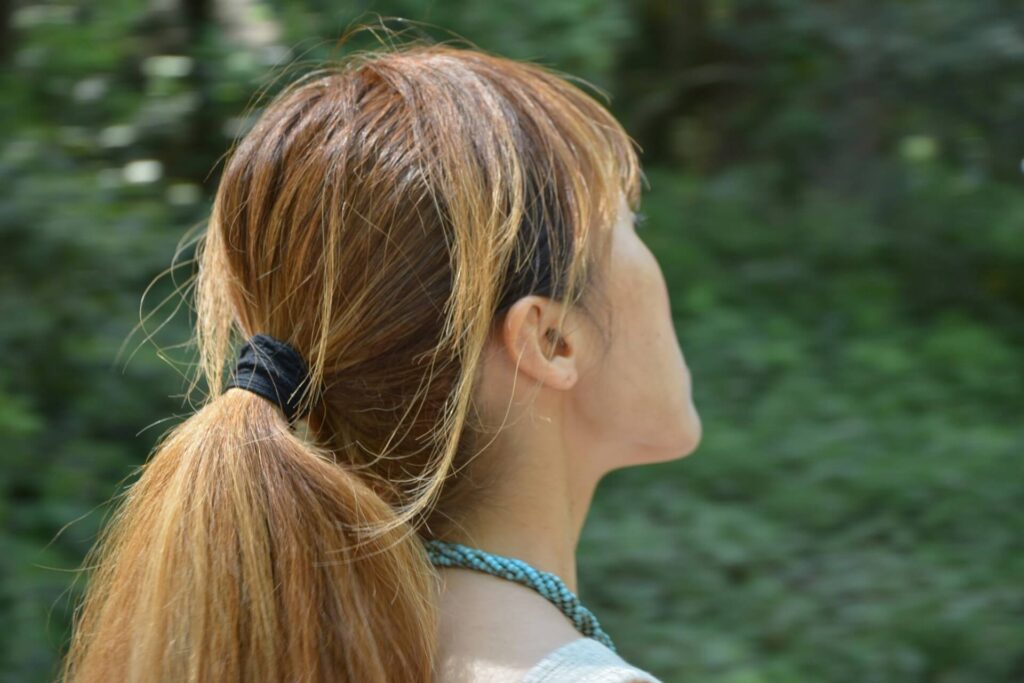 A woman with dyed hair in a ponytail