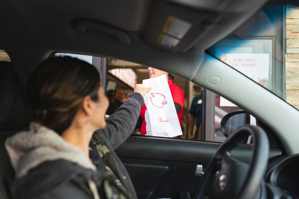 A woman in a drive-through getting a healthy fast food breakfast.