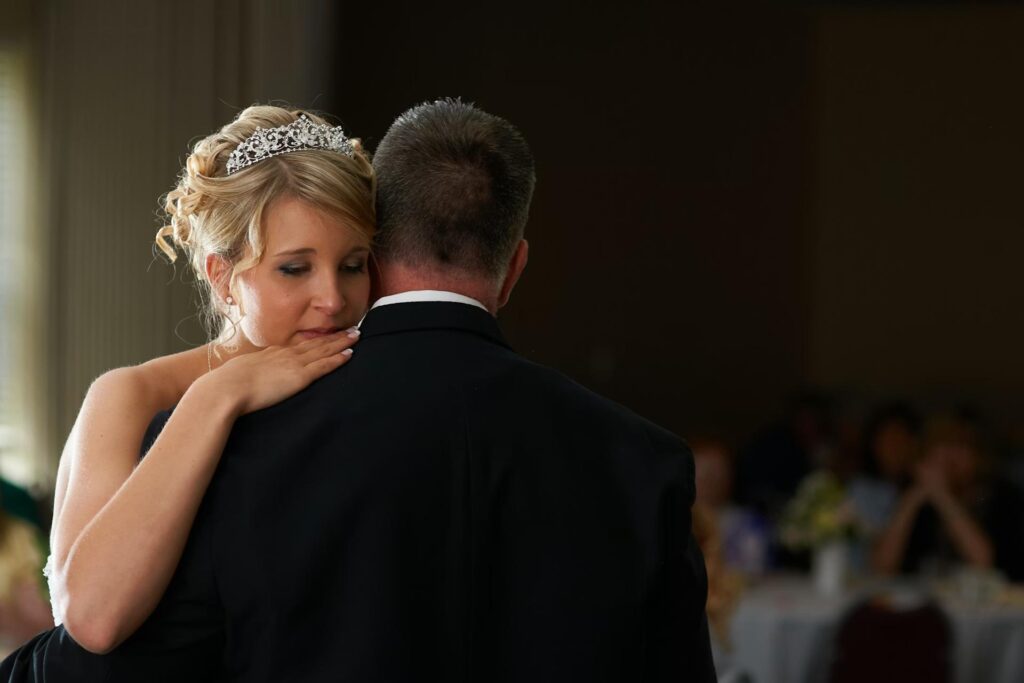 Woman with tiara dancing with man in suit