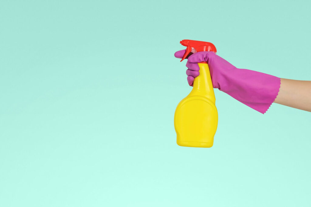 Hand holding a spray bottle of cleaner
