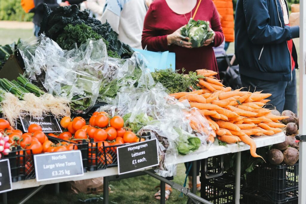 Table with vegetables and person in red standing behind