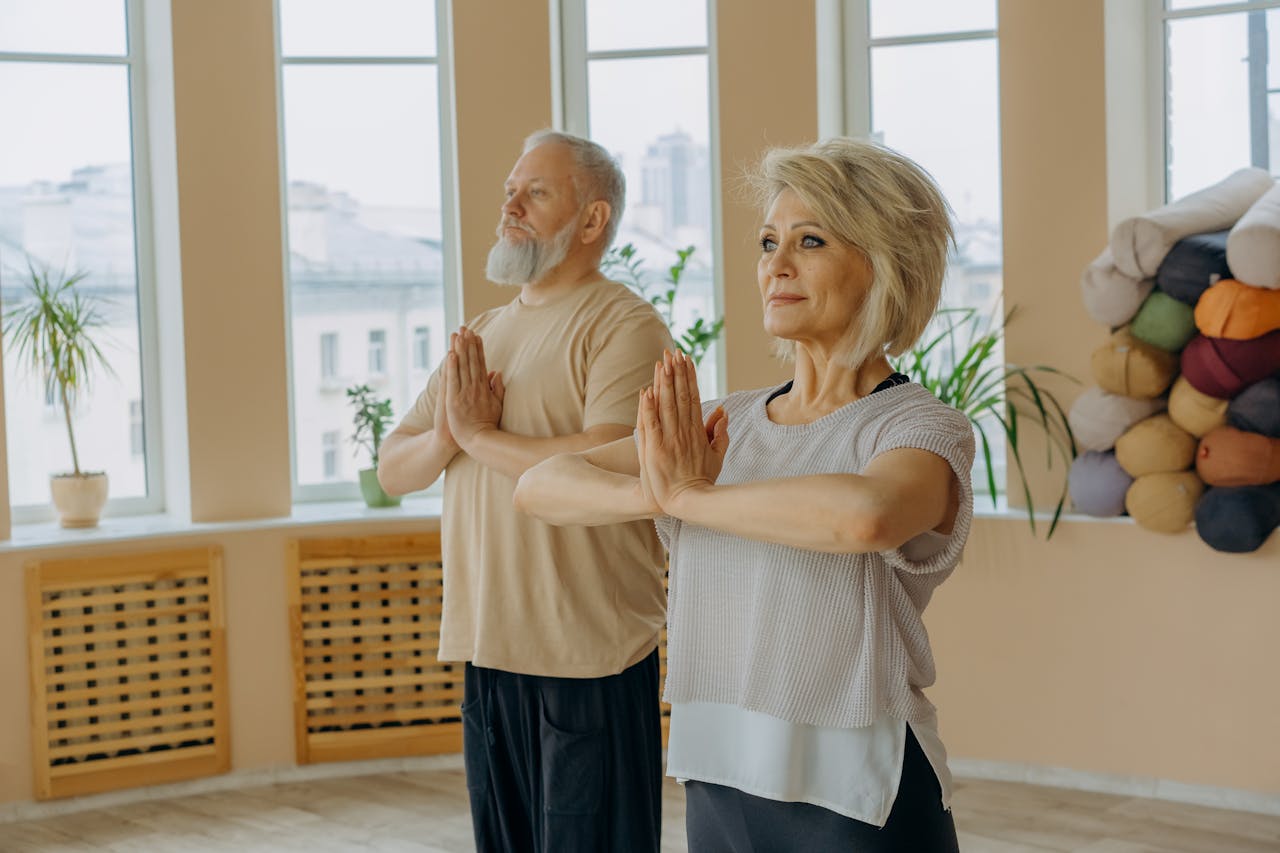 An Elderly Man and Woman Doing Yoga
