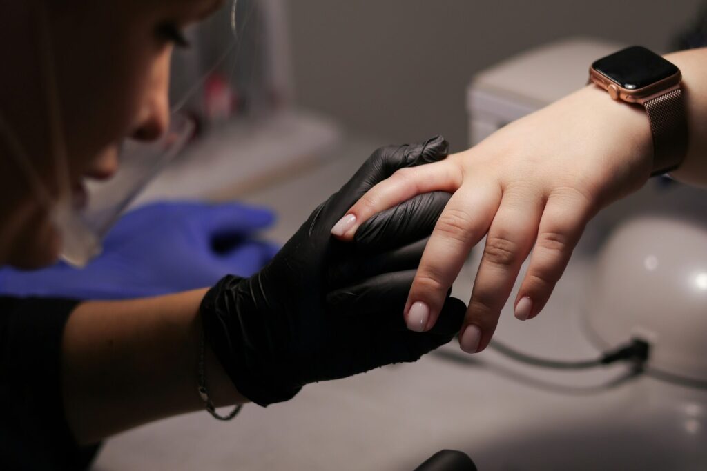 A person receiving a gel manicure