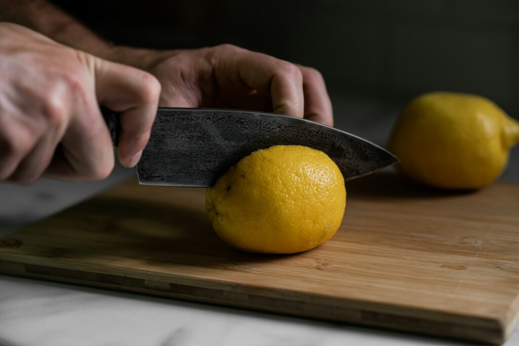 A person cutting a lemon with a knife
