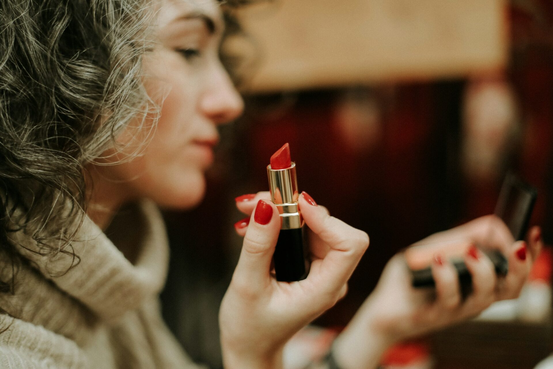 a woman applying red lipstick