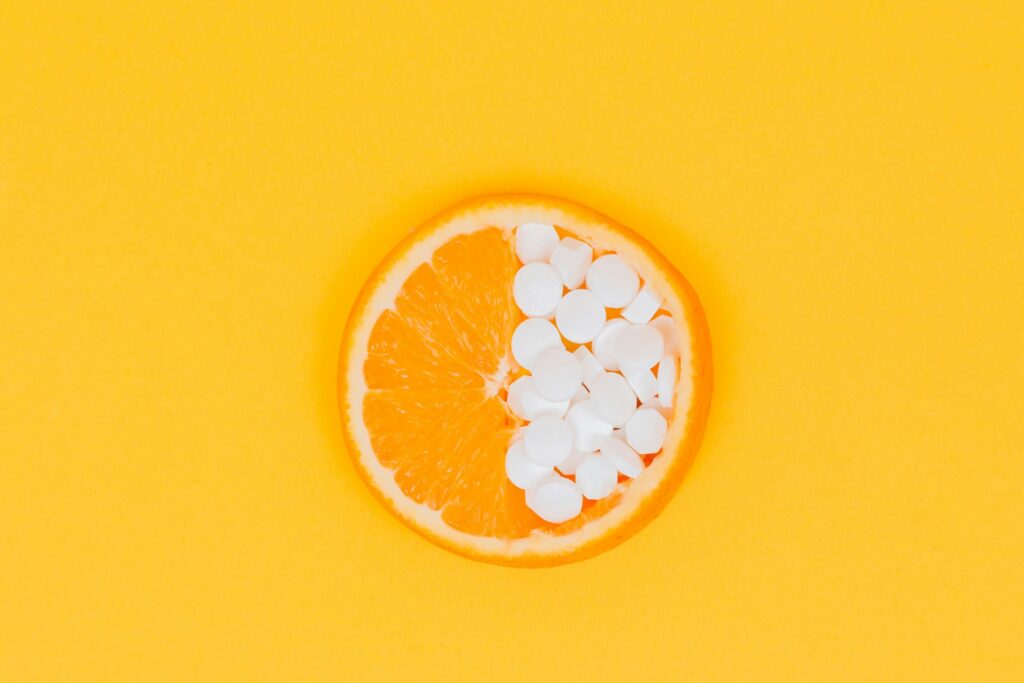 An orange and vitamins to represent vitamin C.
