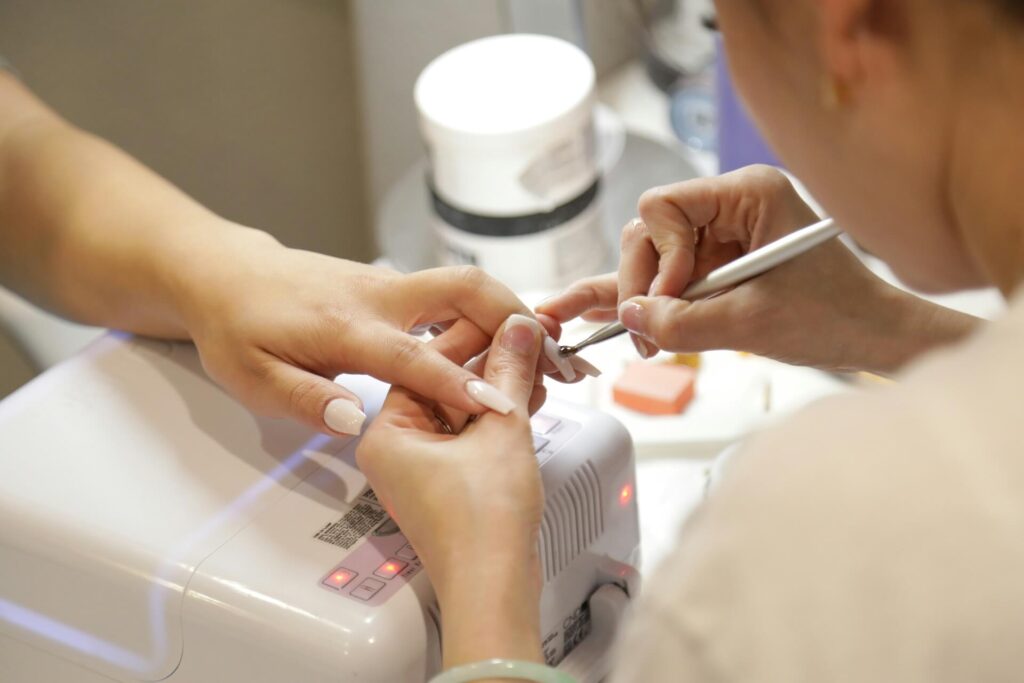 A person receiving a gel manicure