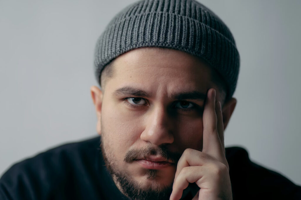 Man in black with gray beanie looking into camera